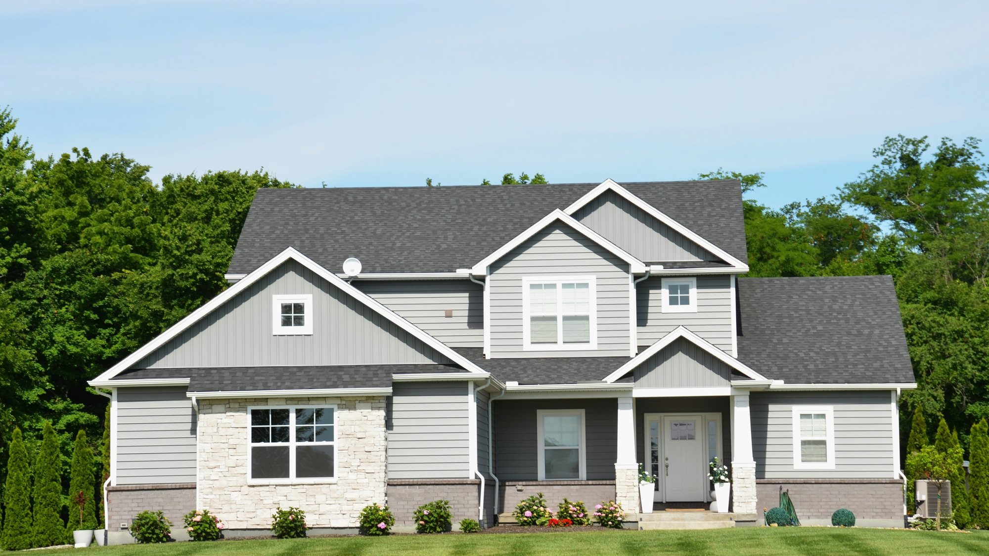 A red brick two-story house with a green lawn